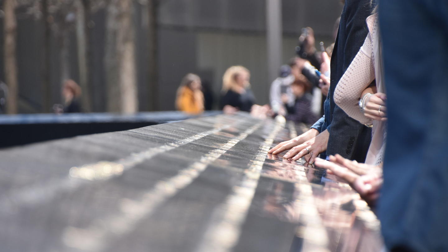 People looking at names on the 9/11 memorial