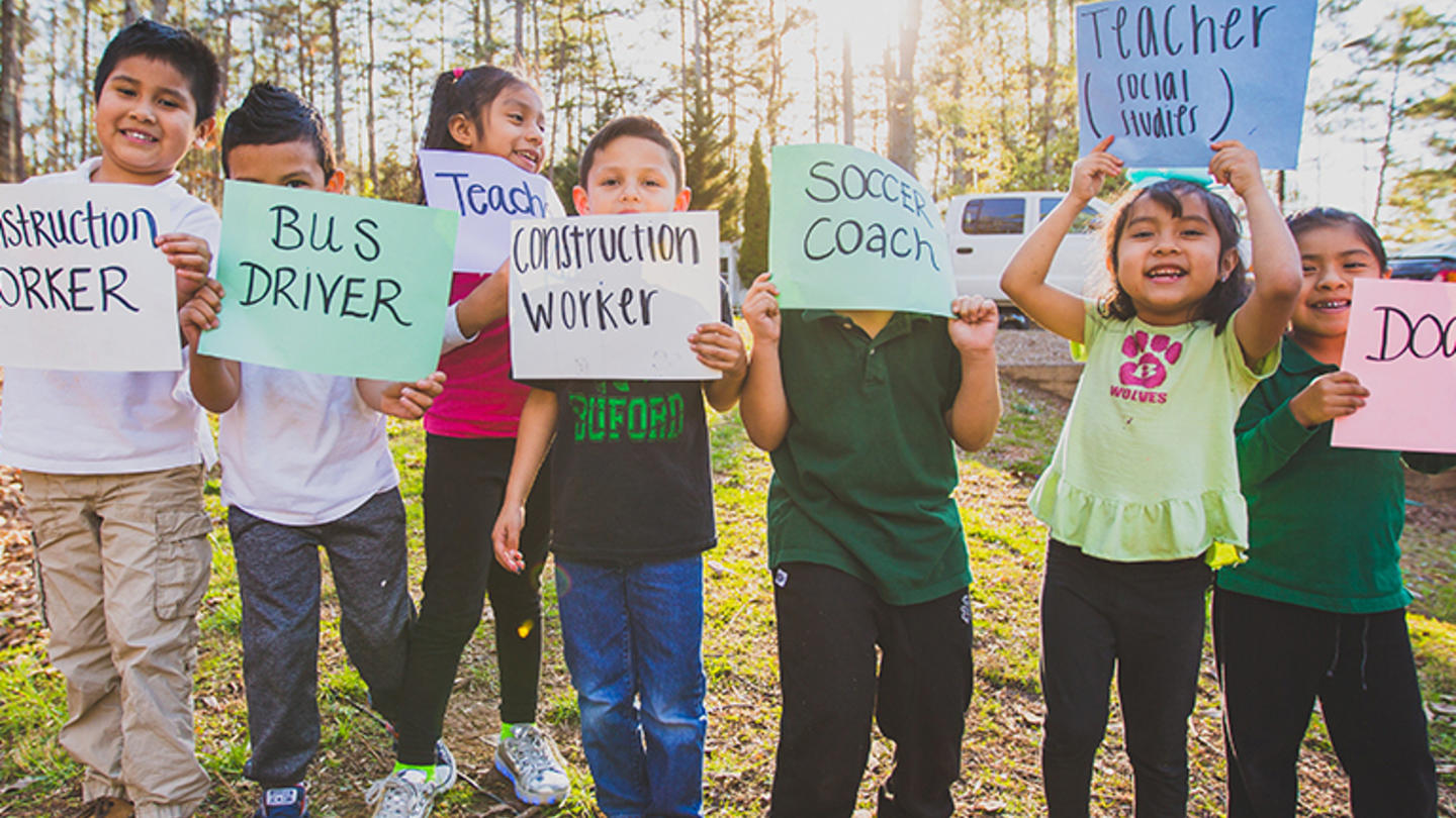 Children holding up signs with their dream jobs
