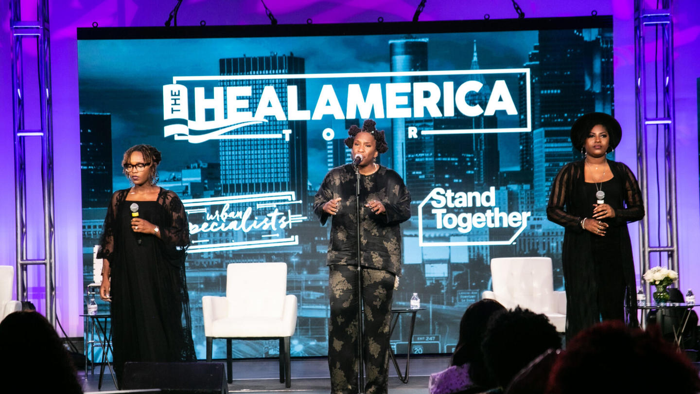 Three women performing at a Heal America event