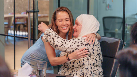 Two women hugging each other.