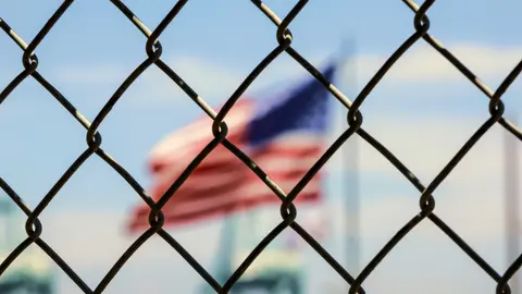 American flag through a fence.
