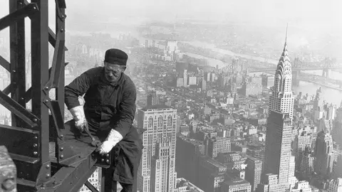 Black and white photo of a worker on a high rise building.