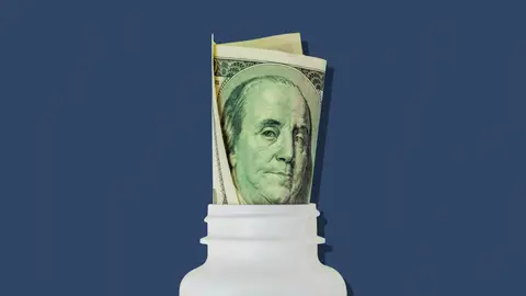 Pill bottle with a rolled up hundred dollar bill.