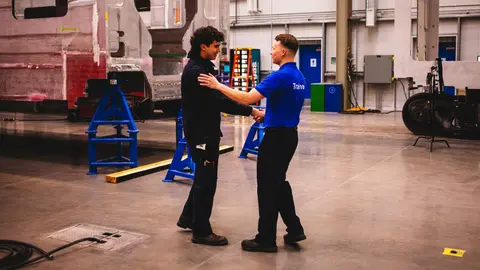 Two workers shake hands at a Stadler Rail facility.
