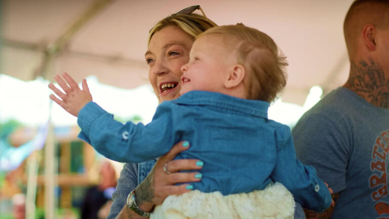 A woman smiling and holding a baby
