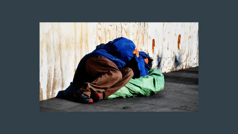 A person who is homeless sleeping on a sidewalk
