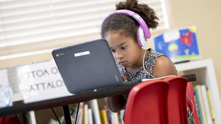 A student learning on a computer in a classroom