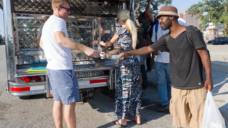 A mobile food van distributes meals to people experiencing homelessness, highlighting community efforts to address the high poverty rate in America.