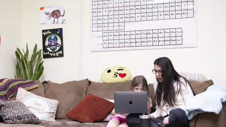 A parent and child engage in personalized learning on a laptop at home, highlighting the benefits of homeschooling through individualized attention and flexible education.