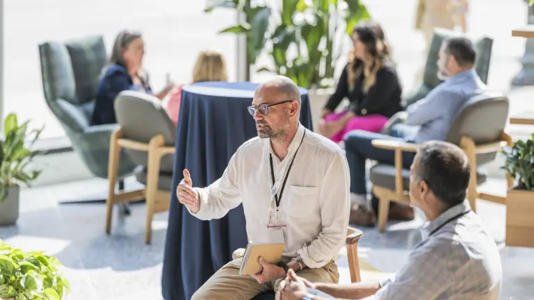 A person speaks to a group, modeling engaged communication and organizational leadership.