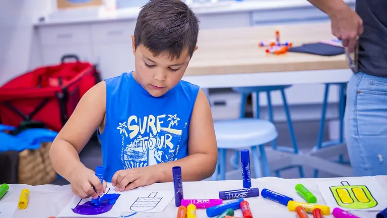 Child explores learning styles while using markets in a hands-on art activity.