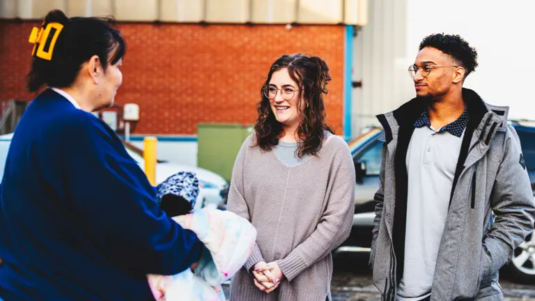 Volunteers handing clothes to someone in need.
