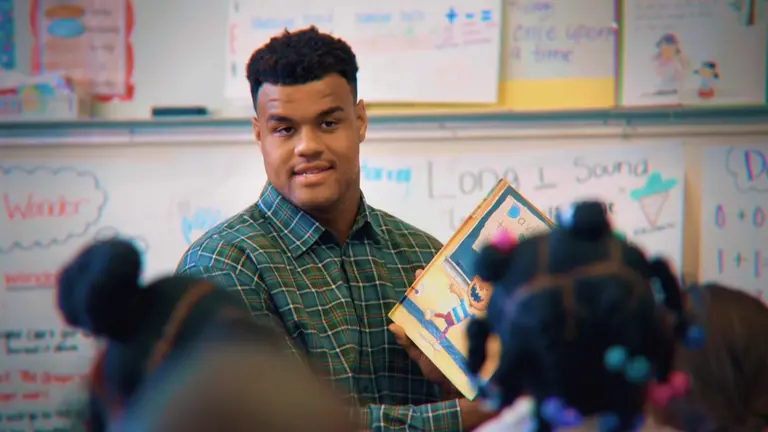 Arik Armstead in a classroom with students.
