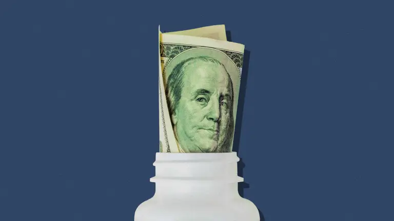 Pill bottle with a rolled up hundred dollar bill.