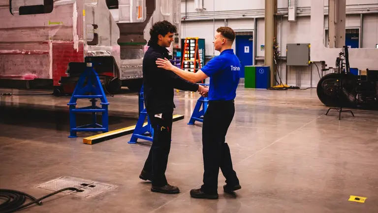Two workers shake hands at a Stadler Rail facility.