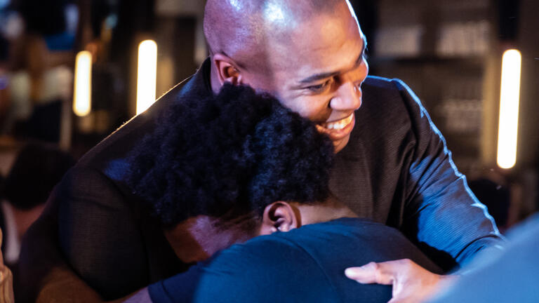 A young man hugs an NFL player
