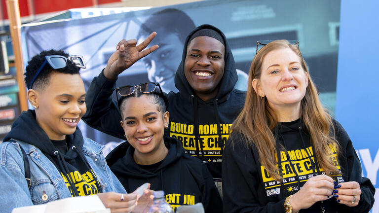 The Cafe Momentum Ambassadors pose for a photo as they prepare meals and swag