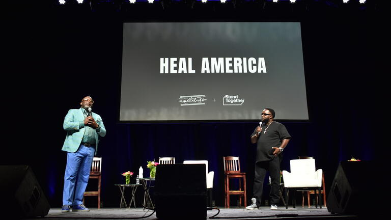 Two speakers on stage at a Heal America event