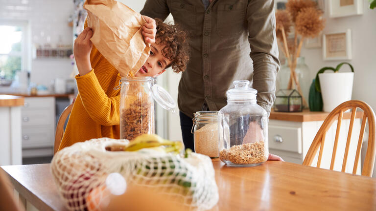 A child pours pretzels into a container