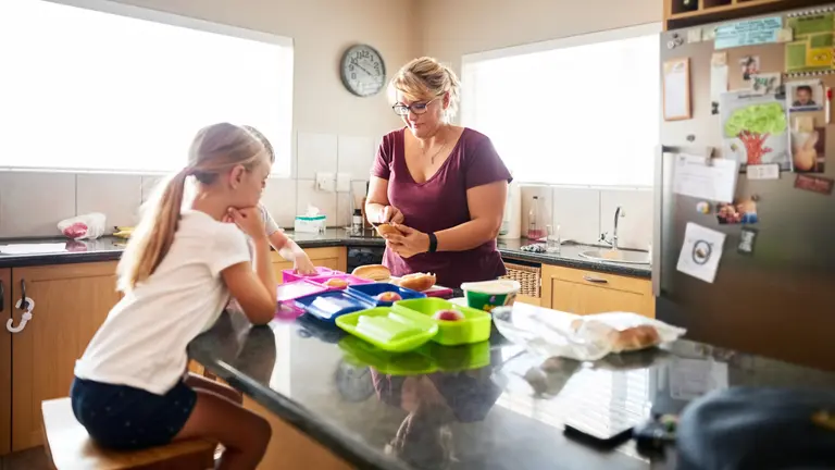 A mother prepares lunches for school