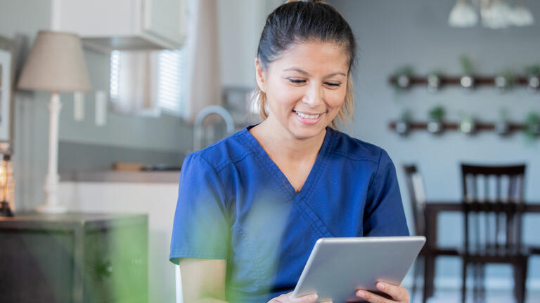 A nurse looking at a tablet
