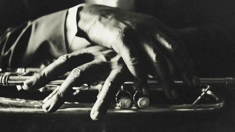 Hands crossed over each other on a trumpet