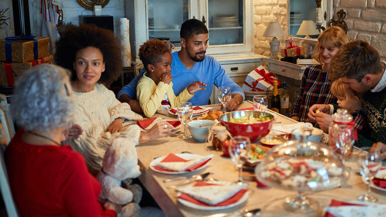 Family getting ready to eat dinner at a table
