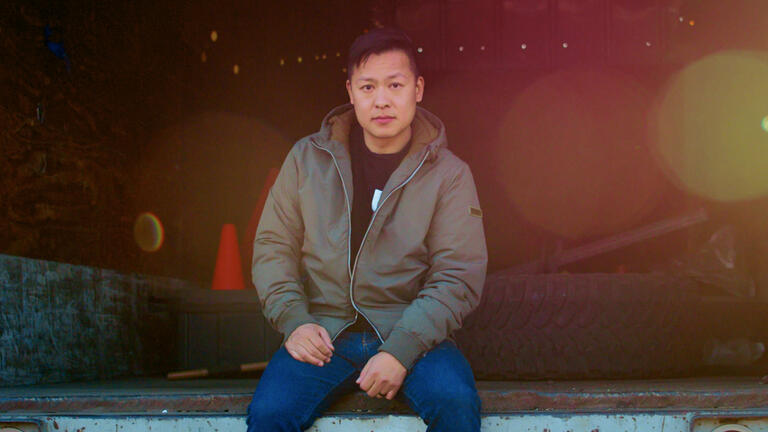 Jason Wang of FreeWorld sitting on a loading dock