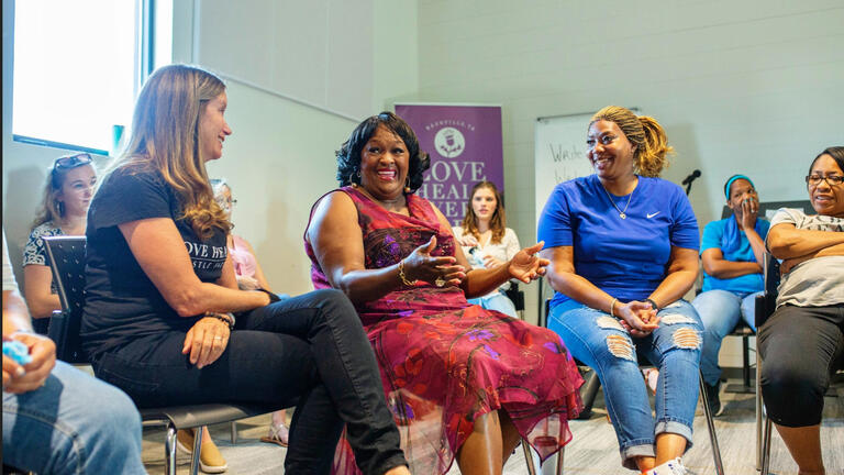 A group of women sitting in a meeting engaged in a discussion