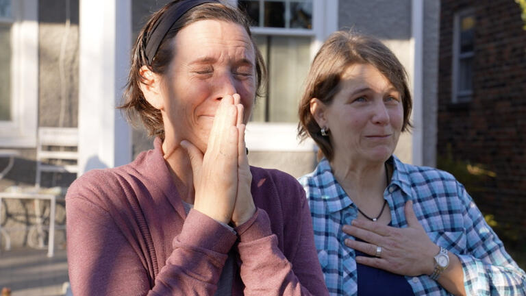 Two women react with joy to a surprise