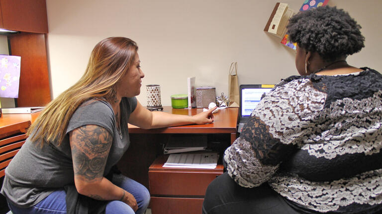 Two women working together on a laptop