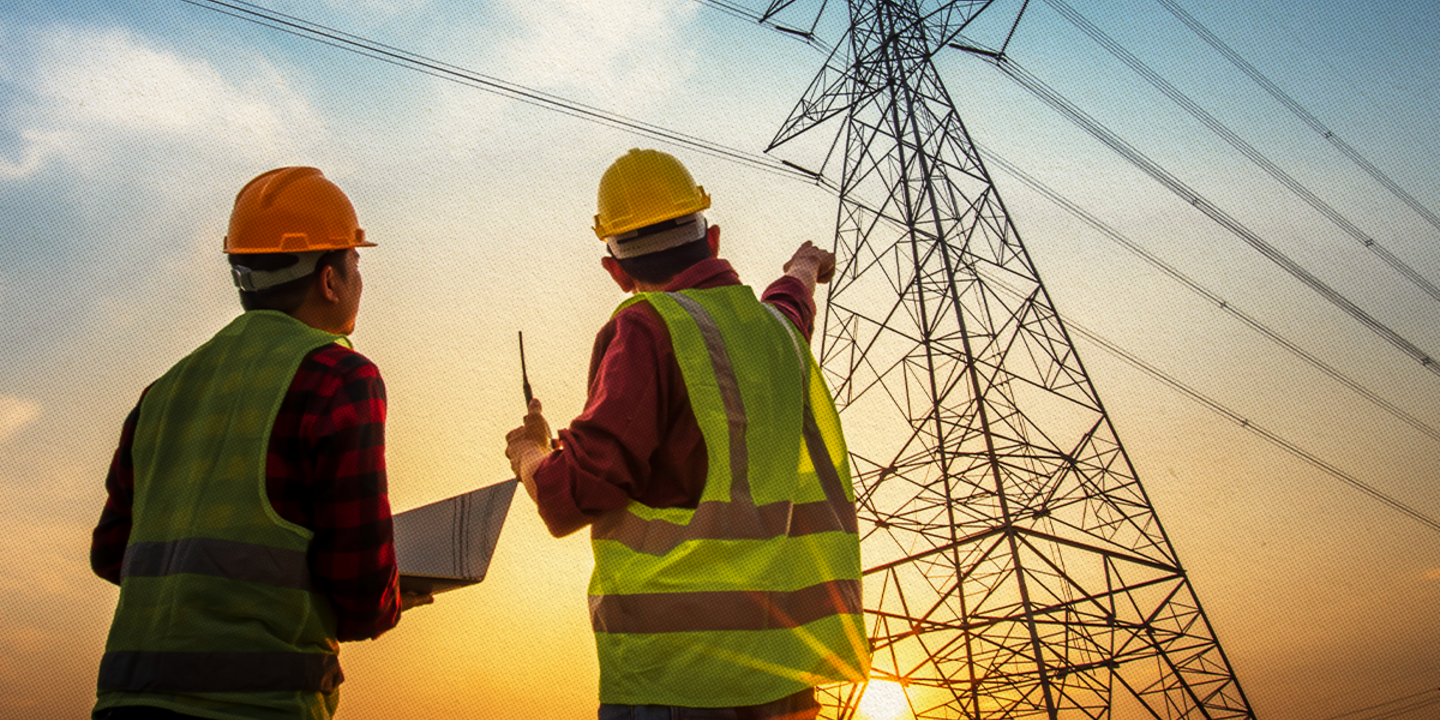 Two energy industry workers pointing at a power line.