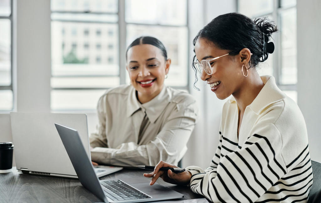 Two women working together at a laptop.