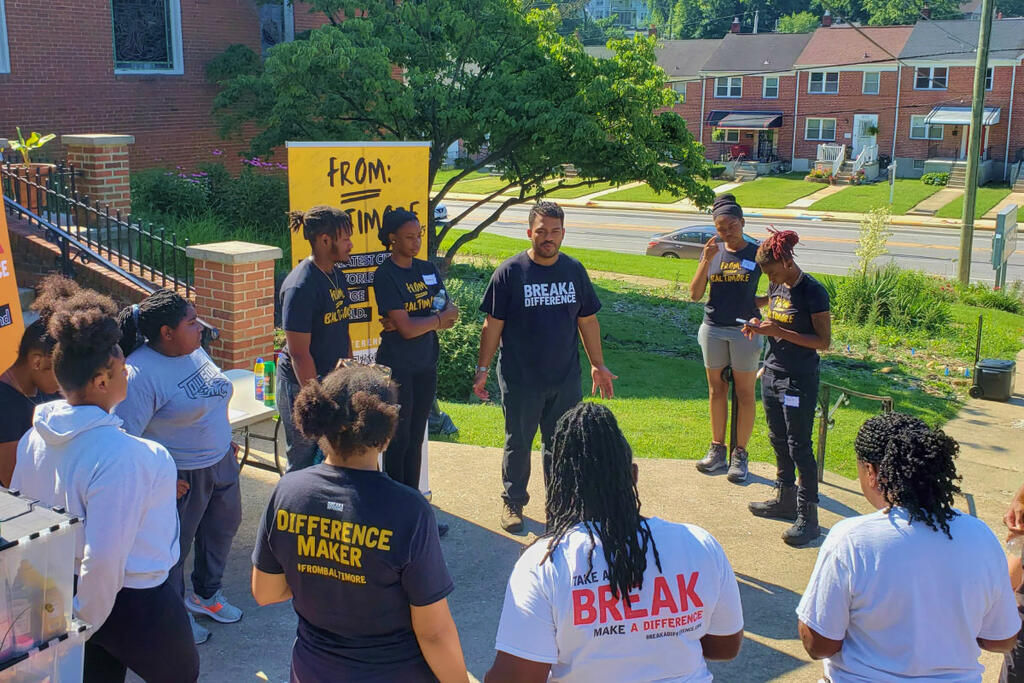 Volunteers gathering together while being welcomed by the CEO and Cofounder of Break a Difference