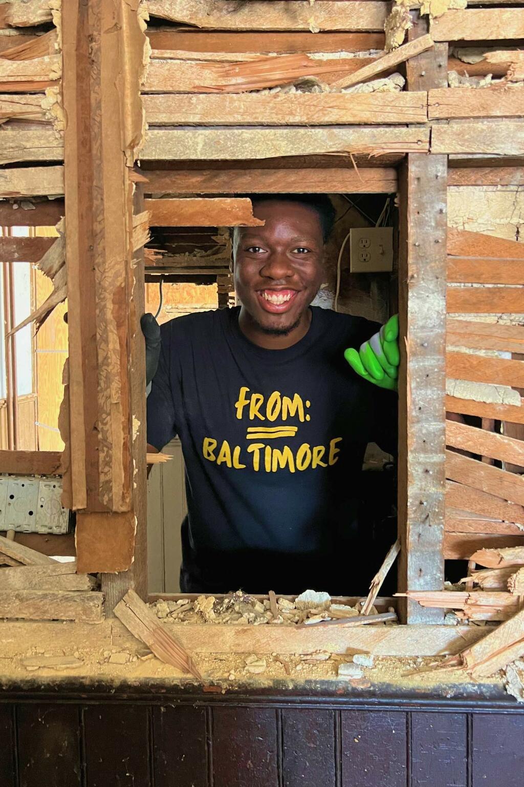 A volunteer looking through a torn down wall of a home that will be rebuilt.