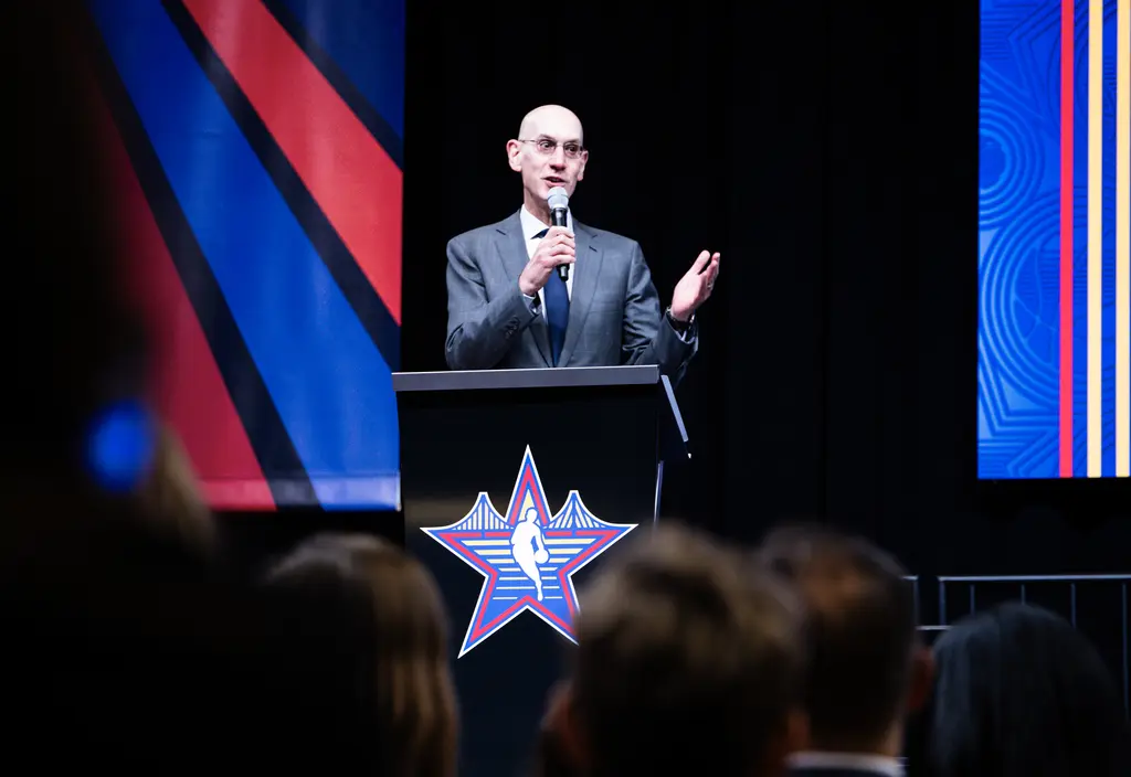 Man speaking on stage into a microphone.