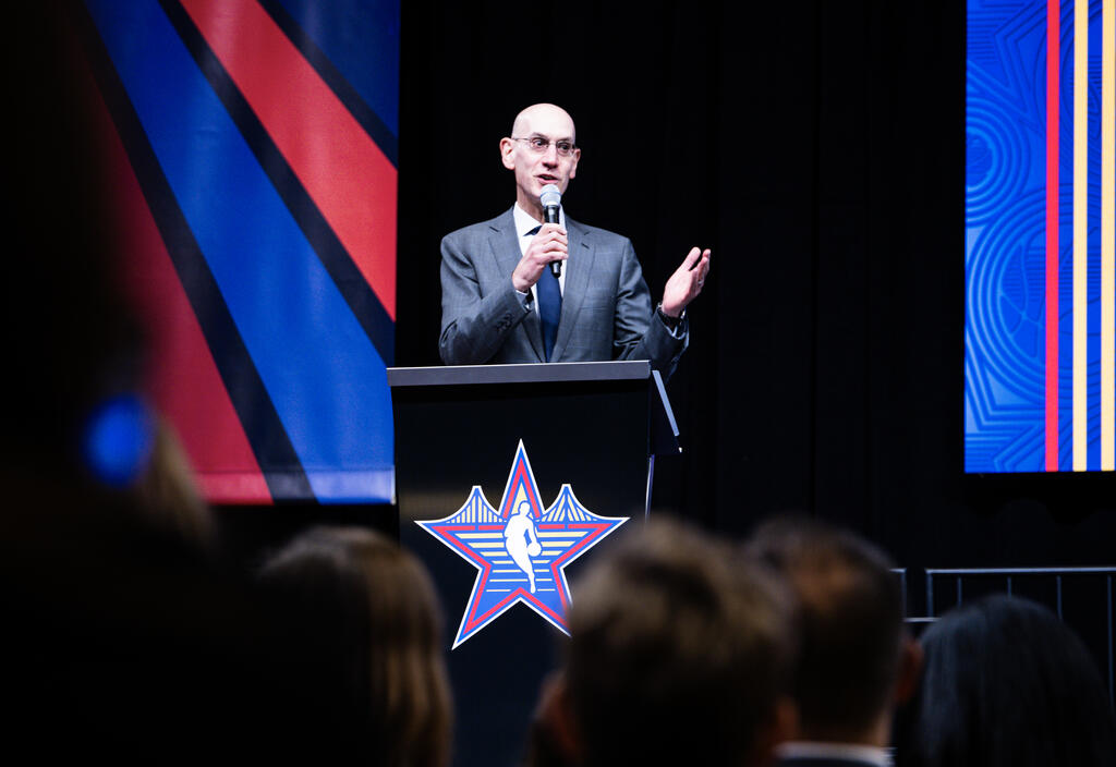 Man speaking on stage into a microphone.