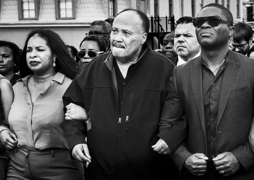 Martin Luther King III with his arm locked with others in support.