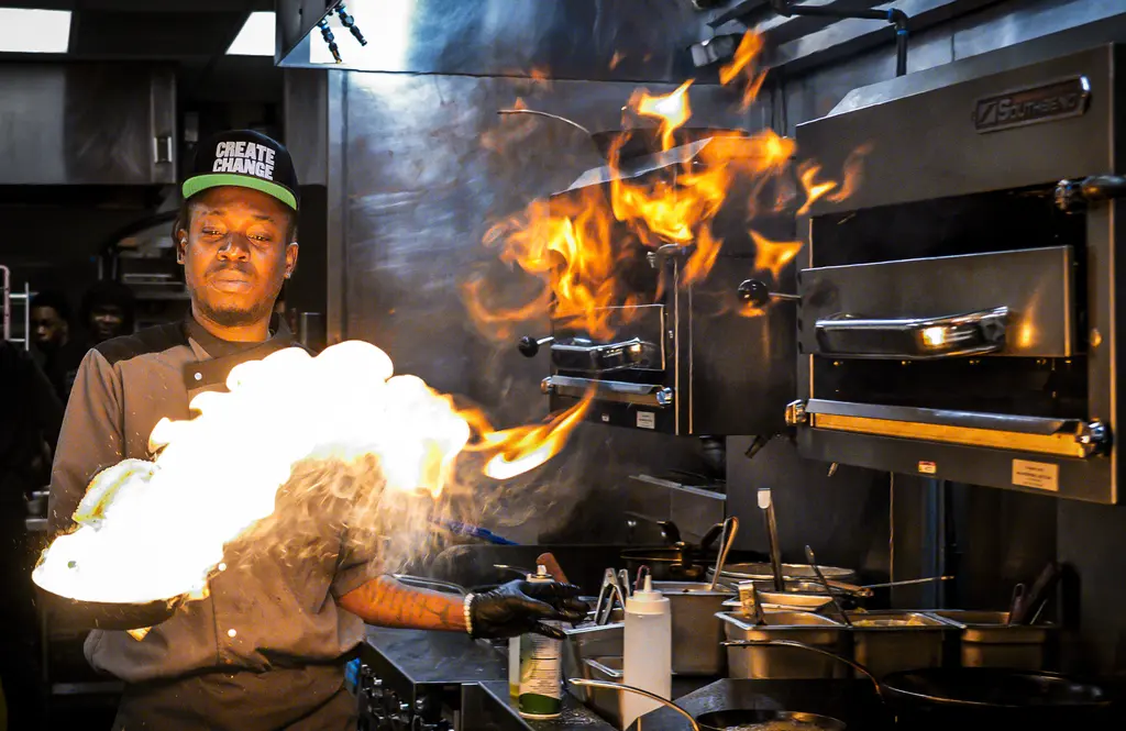 Line cook flambeed entrées for guests.