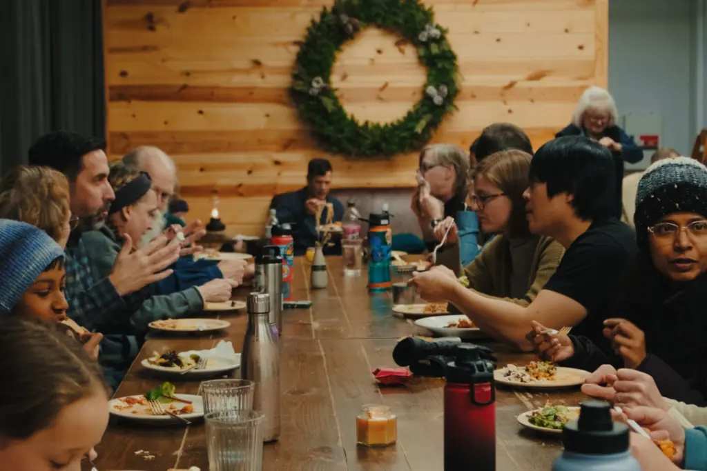 Group of people eating together at a 12-person dining table.
