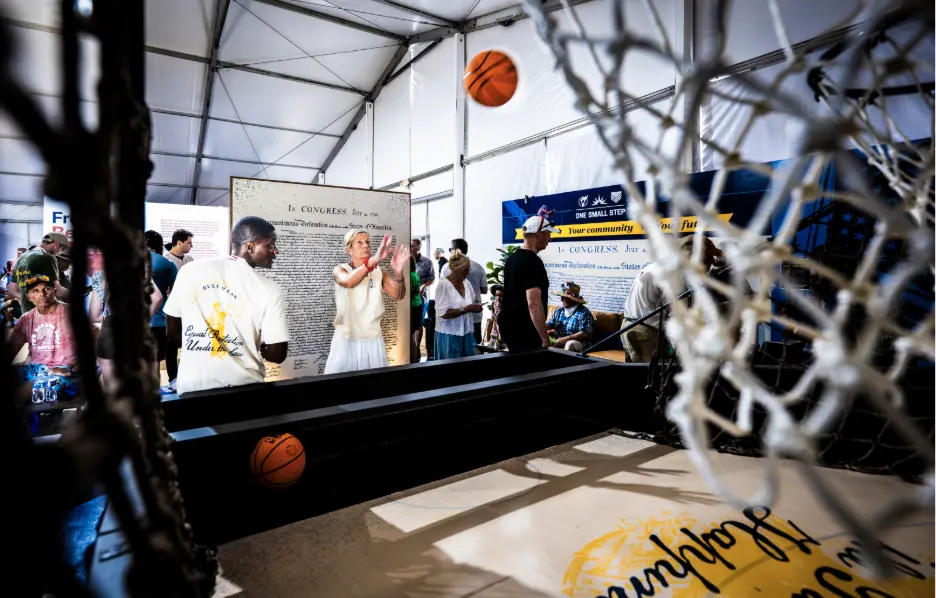 Visitors shoot a basketball at American for Prosperity's exhibit at the Great American State Fair.