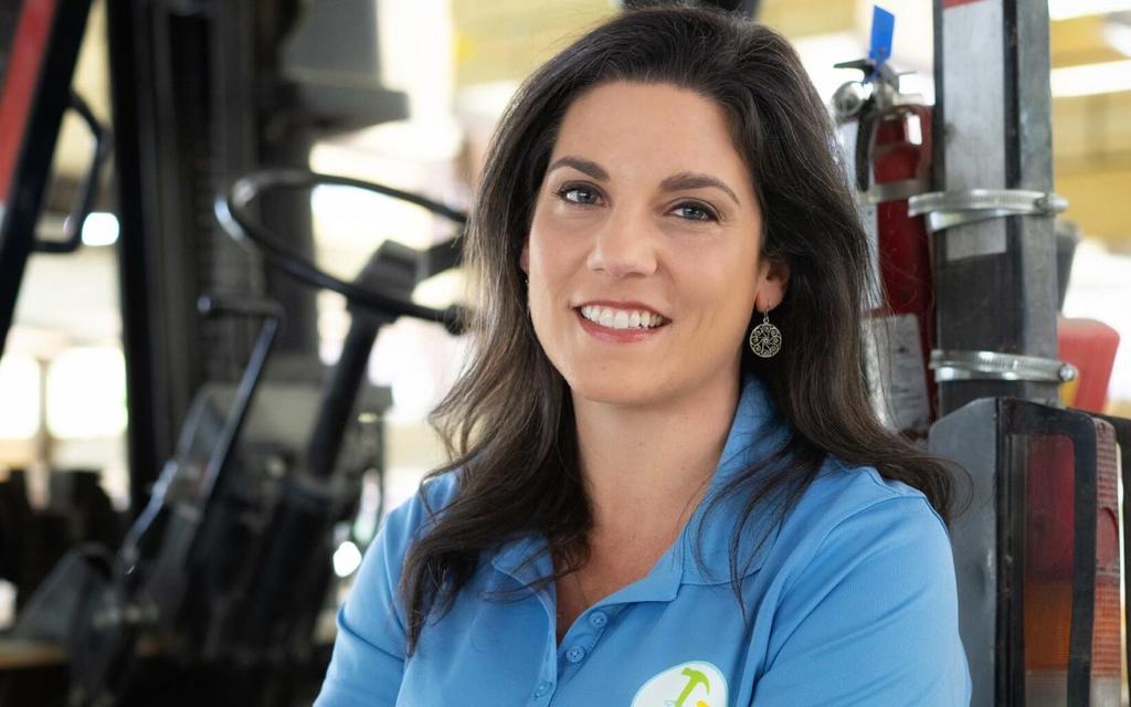 Nora El-Khouri Spencer smiling in front of a forklift