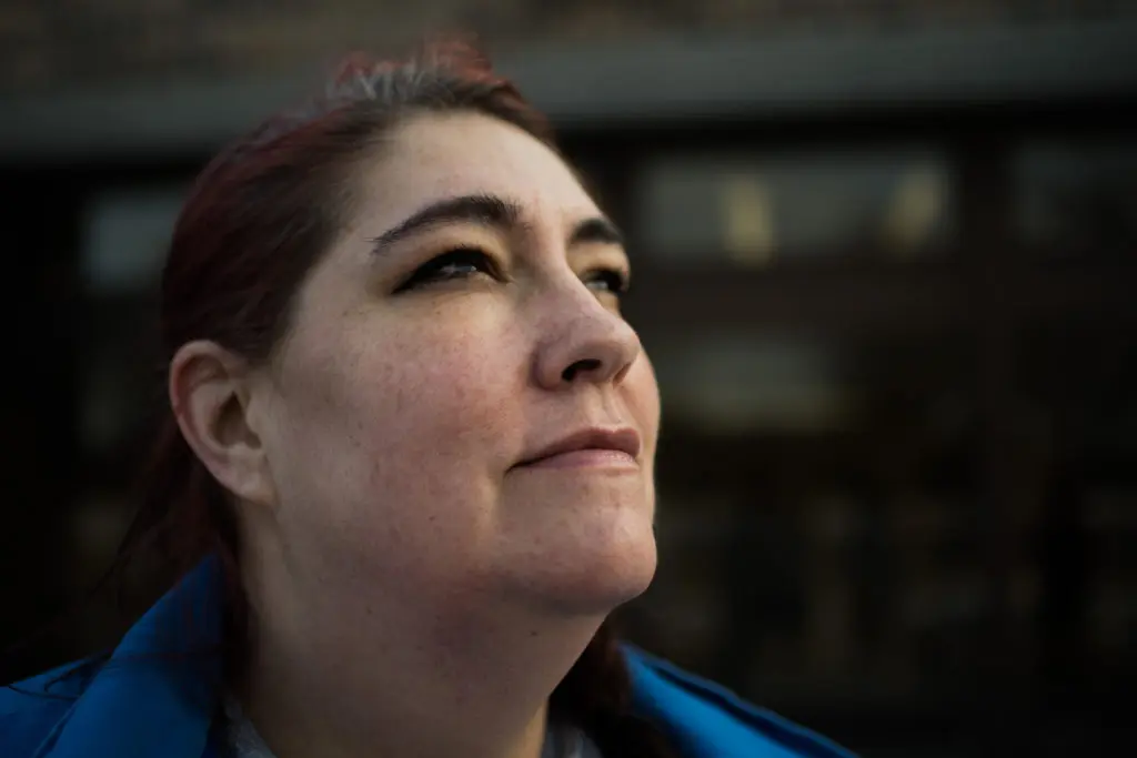 A woman looks up hopefully into the distance