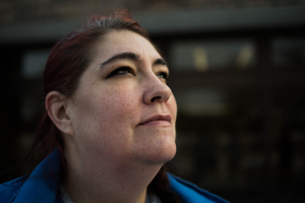 A woman looks up hopefully into the distance