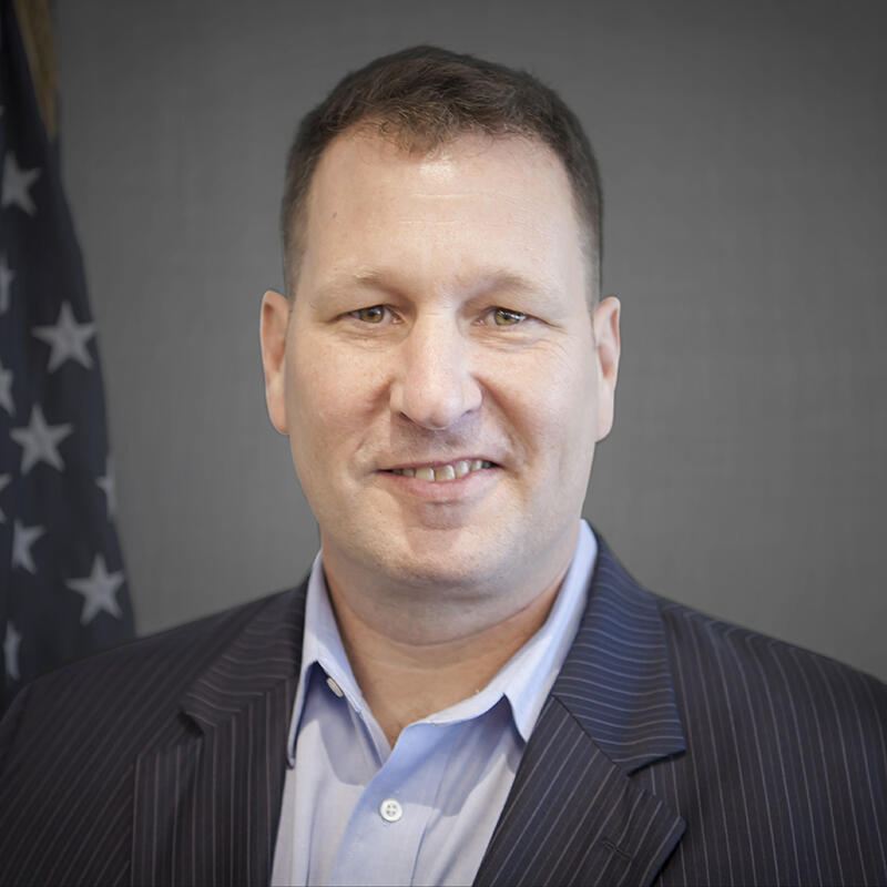 John Byrnes in a suit smiling