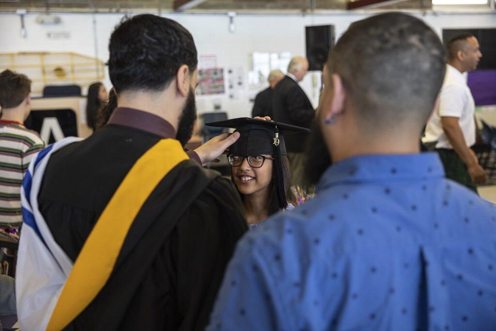 A man adjusts a graduates cap