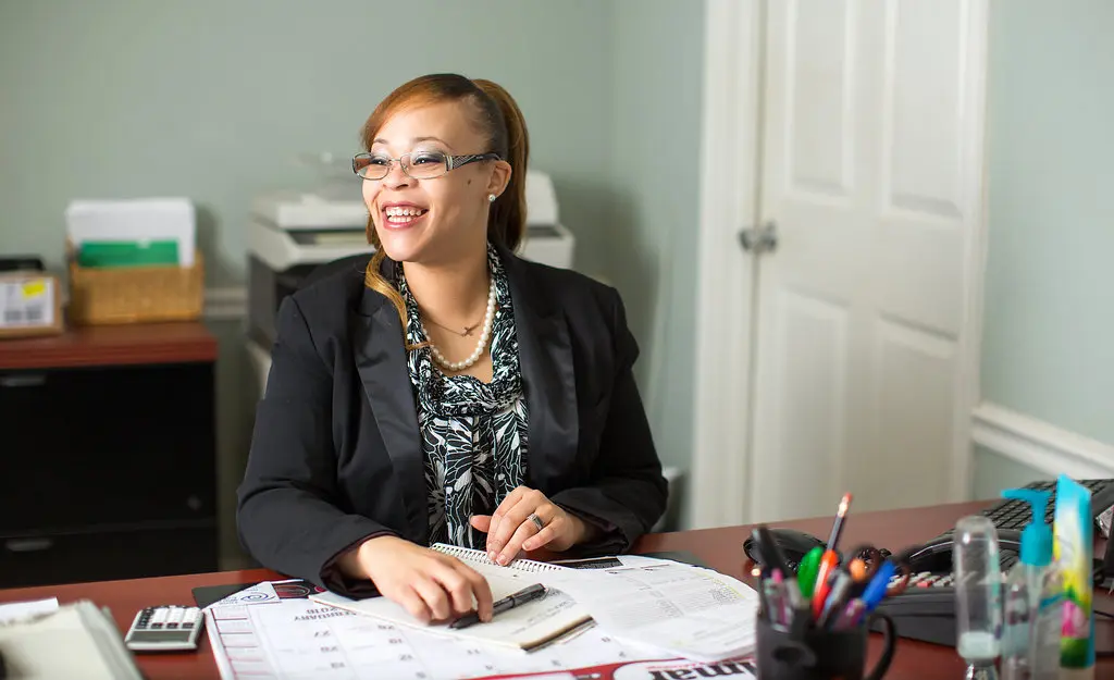 Odessa Moore smiling sitting behind a desk