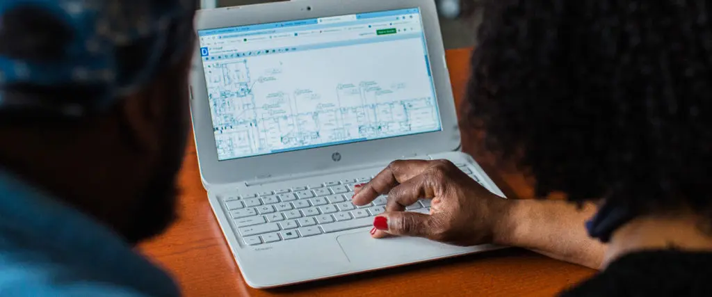 Two people working on a laptop together