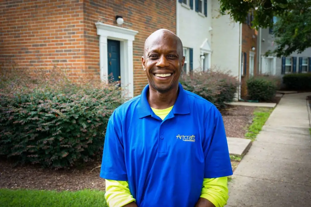 Vonley, Shelters to Shutters participant, smiles as he poses for a photo in front of a house