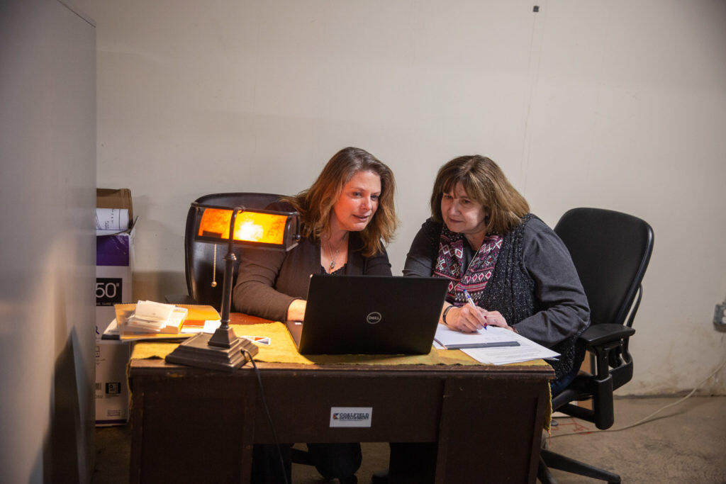 Two women looking at a laptop working
